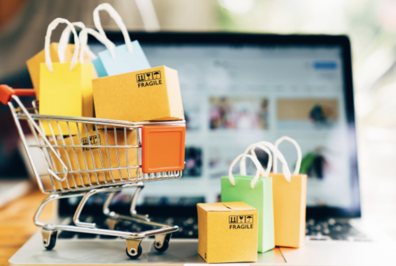 Un carrito de compras y una computadora con tienda online